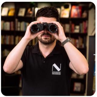 Daniel schaut in Fernglas. Link zu unserem Onlineschaufenster Jetzt vorbestellen.